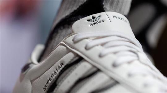 Das Logo und der Schriftzug des Sportartikelherstellers Adidas: Das Unternehmen hat seine neuesten Zahlen vorgelegt.