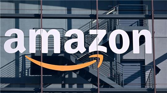 Das Logo und der Schriftzug vom Onlineversandhändler Amazon sind an der Fassade der Zentrale von Amazon Deutschland zu sehen.