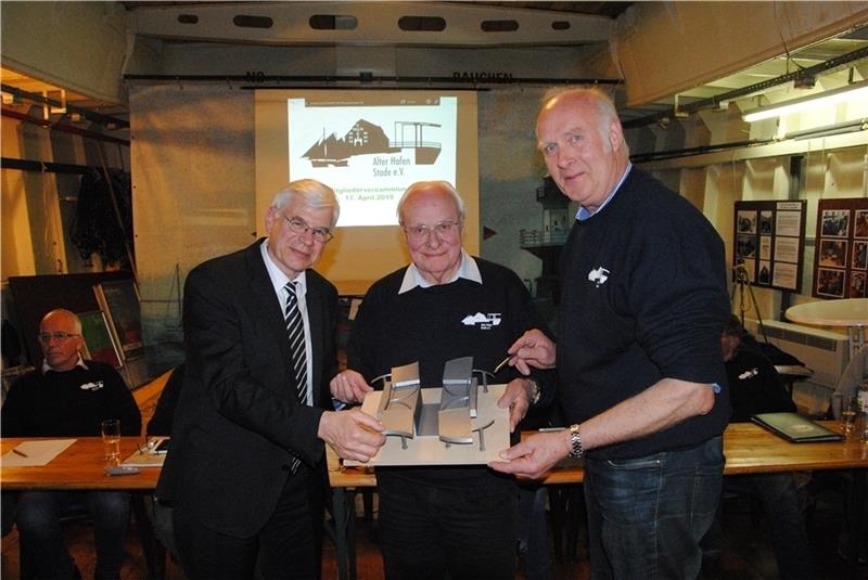 Das Modell einer beweglichen Brücke aus CFK-Kunststoff zeigen (von links) Professor Axel Herrmann und Dieter-Theodor Bohlmann und Klaus Hinrichs vom Verein Alter Hafen. Auf dem Foto ist die Durchfahrt für Schiffe möglich. Wenn sich die vier