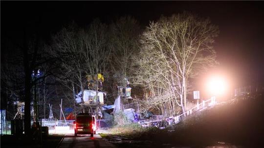 Das Protestcamp „Tümpeltown“ am Südschnellweg wird am Morgen von Scheinwerfern der Polizei ausgeleuchtet.