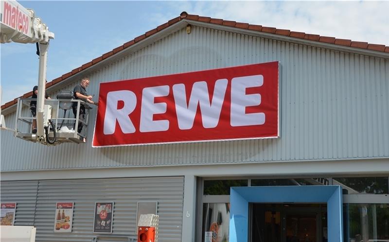 Das Rewe-Logo zeigt von außen: Hier ist ein neuer Markt mit neuem Konzept entstanden. Fotos von Allwörden