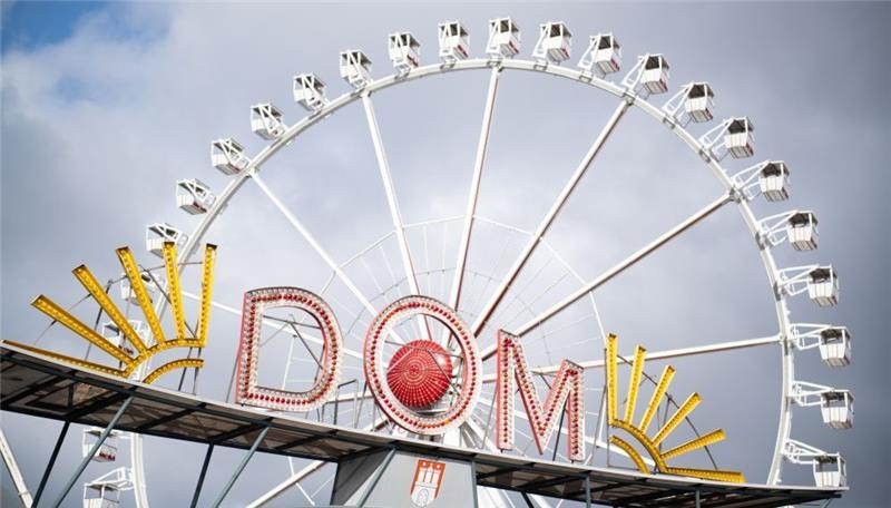 Das Riesenrad auf dem Hamburger Dom ist hinter dem Eingang des Heiligengeistfeldes zu sehen. Foto: Daniel Reinhardt/dpa