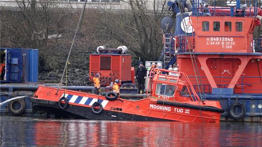 Das Schiff, das in der Nähe der Köhlbrandbrücke gesunken ist, wird mit einem Kran aus dem Wasser geborgen.