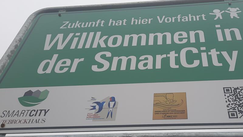 Das Schild der Smart-City weist auch auf den Hochwasserschutz hin (goldene Plakette).
