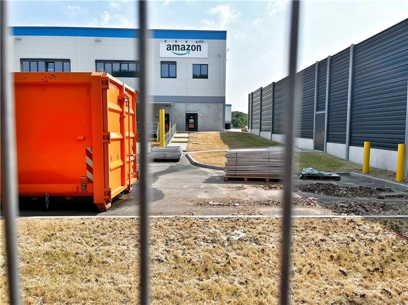 Der Online-Riese Amazon zieht in Stade schon wieder aus Das Schild zur Straße ist noch dran, aber das an der Seite der Halle liegt schon eins am Boden: Blick auf das Gelände des leerstehenden Amazon-Verteilzentrums in Stade. Foto: Richter