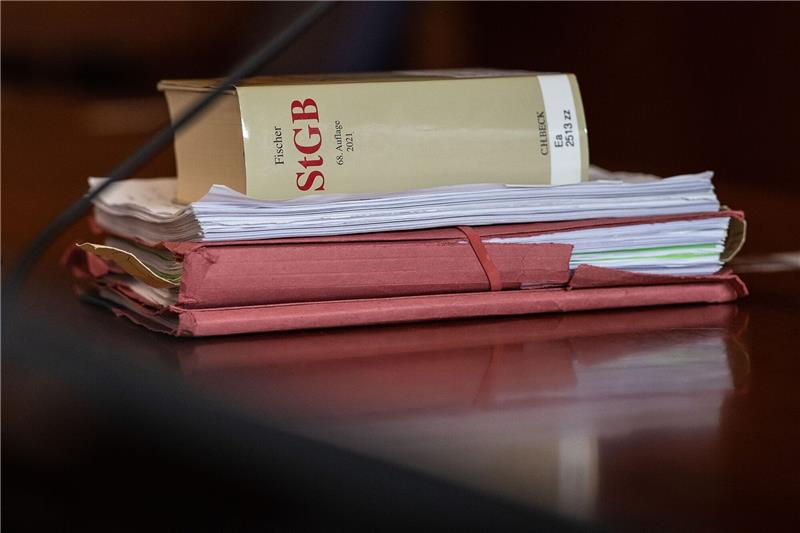 Über eine Million Euro Steuern hinterzogen? – Restaurantbetreiber vor Gericht Das Strafgesetzbuch und Akten liegen in einem Gericht auf dem Tisch.
