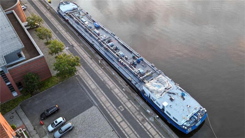 Das Tankmotorschiff „Naima“ liegt nach der Kollision mit der Eisenbahnbrücke in Elsfleth. Wo einmal das Brückenhaus war, ist nur noch eine Plane zu sehen. Gegen den Schiffsführer wird ermittelt. 