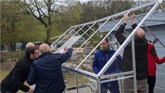 Das Team von Airbus gemeinsam mit dem Kita-Team beim Aufbau des neuen Gewächshauses.