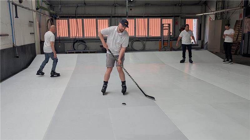 Tausende Liter Wasser und Kreppband: So entsteht in Harsefeld die Eisfläche Das Team von Glice testet die Oberfläche selbst.