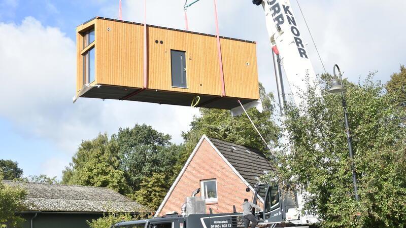 Das Tiny-House-Modul wird mit dem Kran an Ort und Stelle gesetzt.