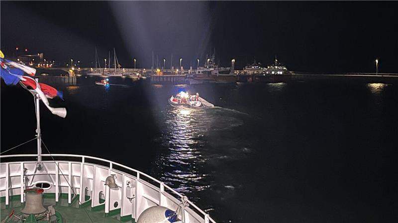 Das Tochterboot "Verena" schleppt das schwer beschädigte Sportboot in den Hafen von Helgoland. Das Foto wurde vom Bug des Seenotrettungskreuzers "Hermann Marwede" aus aufgenommen.