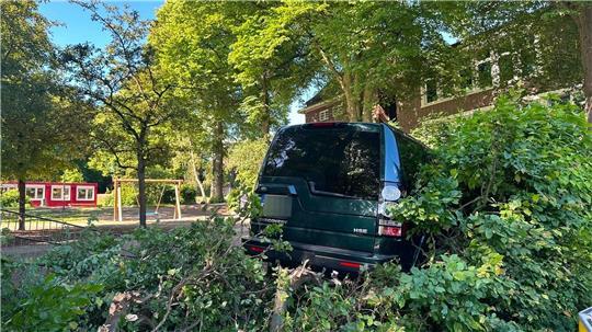 Das Unfallfahrzeug steht im Gebüsch vor einer Schule im Stadtteil Blankenese.