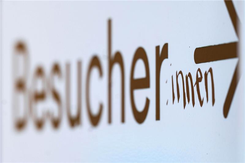 Das Wort „Besucher“ ist auf einem Hinweisschild mit dem Zusatz «:innen» versehen. Foto: Marijan Murat/dpa