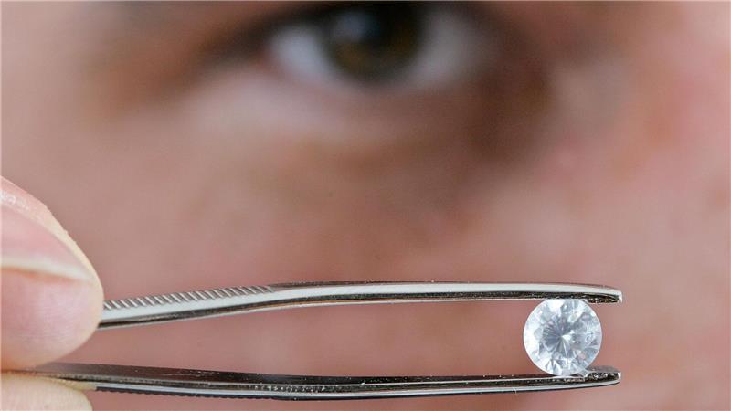 Das ein Karat große Musterbeispiel eines Diamanten aus Totenasche hält der Inhaber des Bestattungsinstituts „Crist-All Bestattungen“ in Berlin mit einer Pinzette.