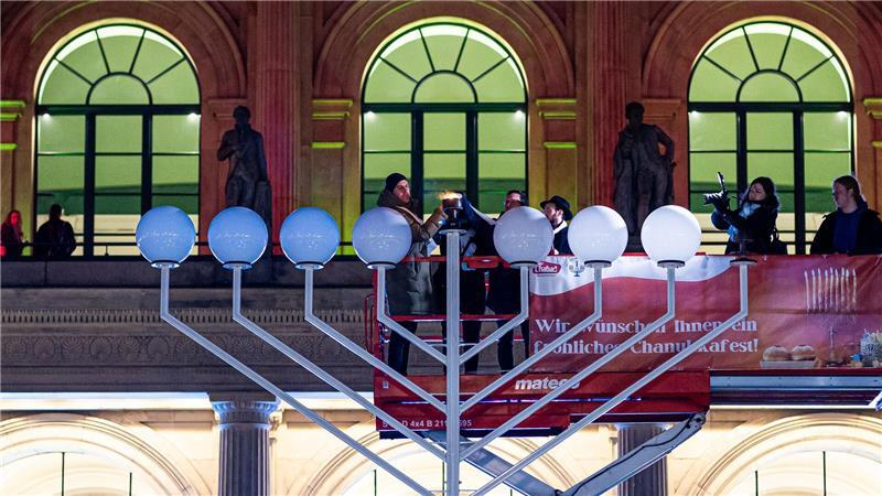 Das erste Licht am Leuchter wird entzündet.