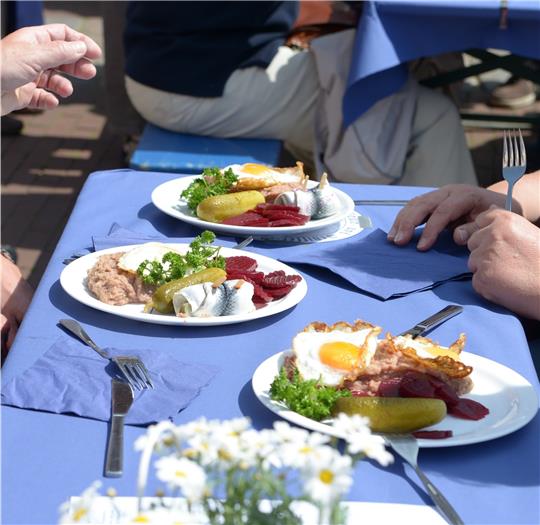 Das gehört zum Labskaus dazu: Kartoffelbrei mit Pökelfleisch, saure Gurke, Rollmops, Spiegelei und Rote Beete. Foto Stader Marketing und Tourismus Gesellschaft / Martin Elsen