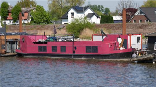 Das pink-farbene Hausboot, auf dem eine 58 Jahre alte Frau tot aufgefunden worden war, liegt an einem Steg im Holzhafen im Stadtteil Moorfleet. 
