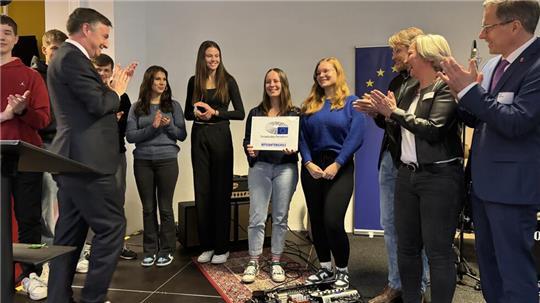 David McAllister übergab die Plakette „Botschafterschule für das Europäische Parlament“ im Beisein von Landrat Kai Seefried (rechts) an Schulleitung und Schüler.