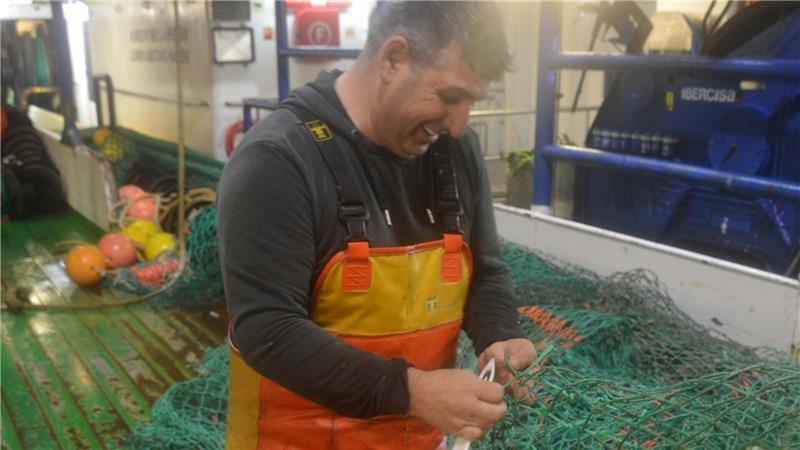 Decksmann Manuel Moreira flickt das Netz. Der 50-Jährige hat das Fischen in seinem Heimatland Portugal gelernt, bevor er nach Deutschland kam.