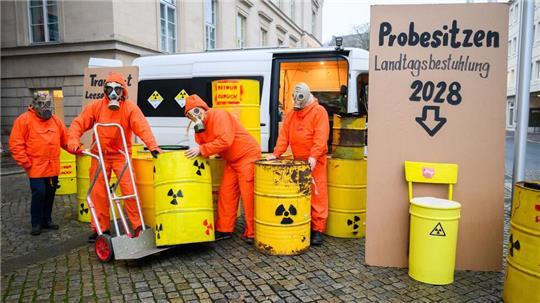 Demonstranten der Bürgerinitiative Strahlenschutz Leese stehen mit künstlichen Atommüllfässern vor dem niedersächsischen Landtag.