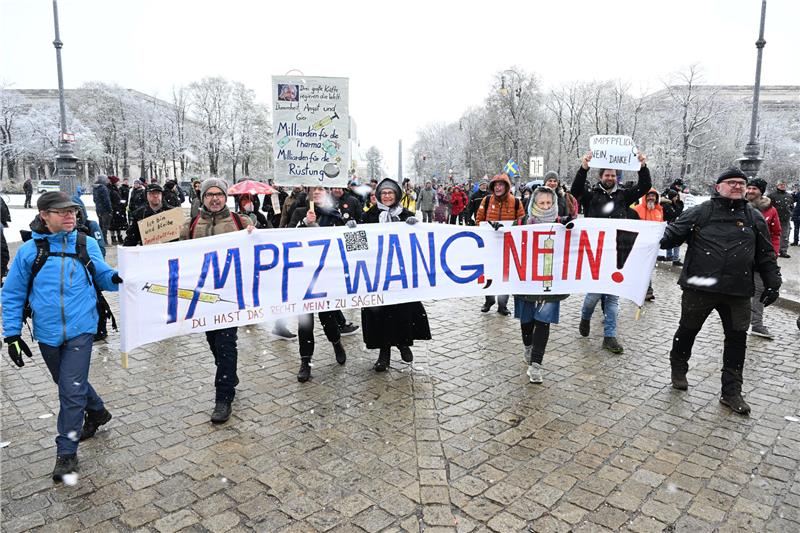 Demonstranten gehen mit einem Banner mit der Aufschrift "Impfzwang nein!". Foto: Felix Hörhager/dpa