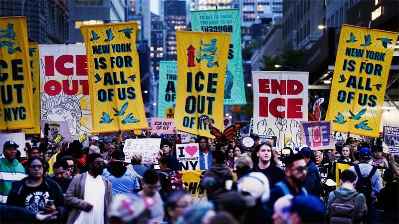 Demonstranten marschieren während einer Protestkundgebung gegen die Einwanderungsbehörde ICE durch die Straßen von New York und halten Plakate.