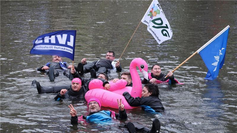 Demonstranten schwimmen in der kalten Elbe.