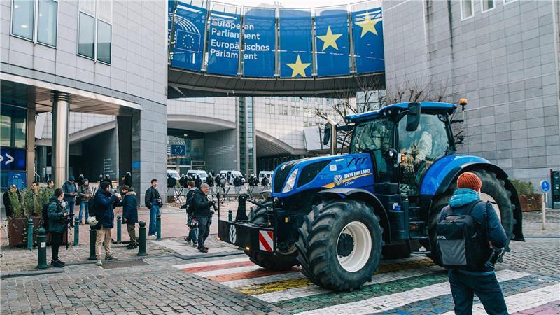 Demonstranten und Bereitschaftspolizei stehen vor dem Eingang des Europäischen Parlaments.