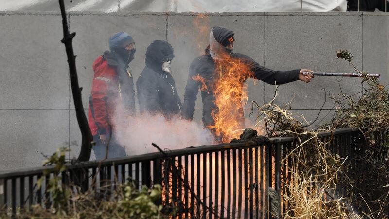 Demonstranten zünden während Bauernprotesten, in der Nähe des Gebäudes des Europäischen Rates, Heu an. 