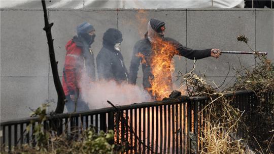 Demonstranten zünden während Bauernprotesten, in der Nähe des Gebäudes des Europäischen Rates, Heu an. 