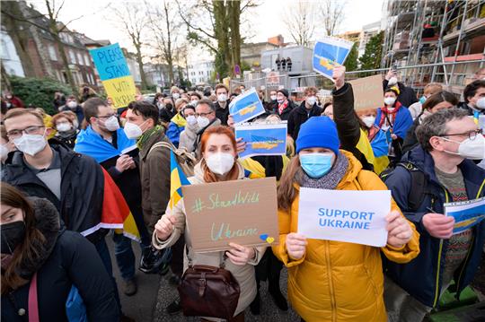 Demonstrantinnen zeigen Plakate mit der Aufschrift "#StandWithUkraine" und "Support Ukraine". Rund 200 Menschen haben sich laut Polizei am Mittwoch vor dem russischen Generalkonsulat in Hamburg zu einer Solidaritätskundgebung mit der Ukraine versammelt. Aufgerufen zu der Kundgebung hatten die Hamburger Jugendorganisationen von SPD, Grünen, CDU und FDP. Foto: Jonas Walzberg/dpa