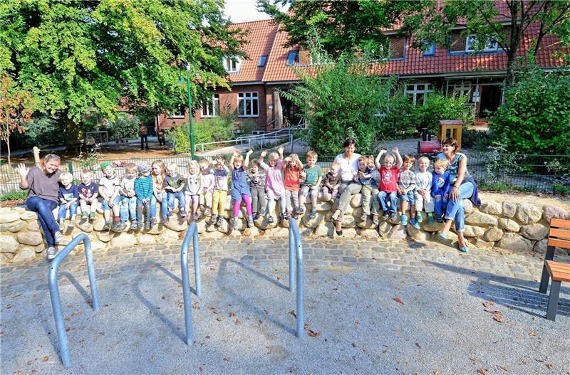 Fußwegbau beendet die Dorferneuerung in Hollenbeck Den Dorfplatz umrahmt seit 2014 eine Feldsteinmauer , auf der die Kinder für ein Foto Platz nahmen.