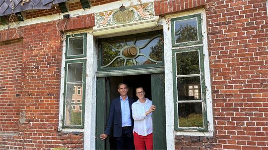 Denkmalretter: Inga und Jan Thesing vor der schmucken Tür am Südgiebel ihres Hauses Am Fleet 14 in Jork - mit Engeln und Biertonne.