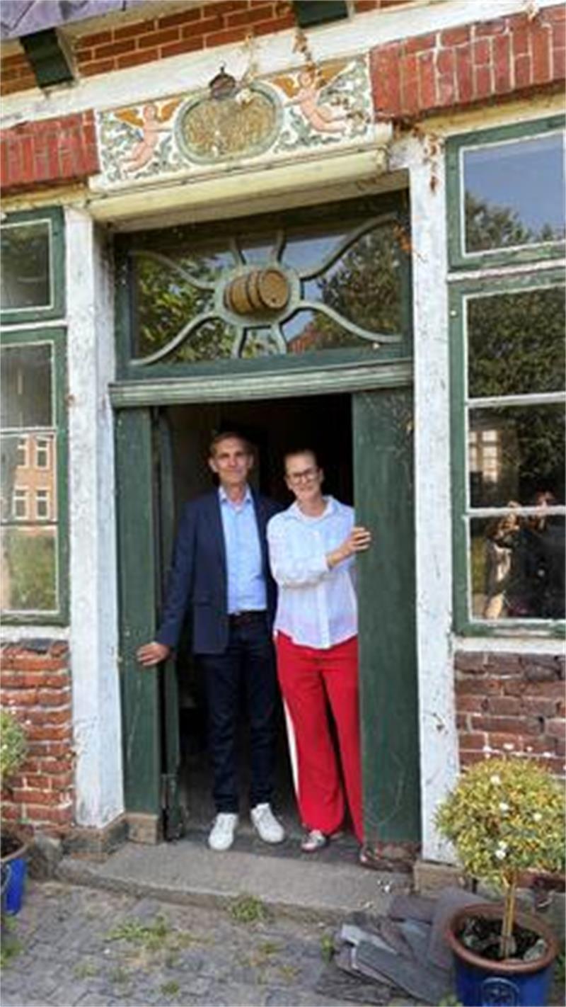 Denkmalretter: Inga und Jan Thesing vor der schmucken Tür am Südgiebel ihres Hauses Am Fleet 14 in Jork - mit Engeln und Biertonne.