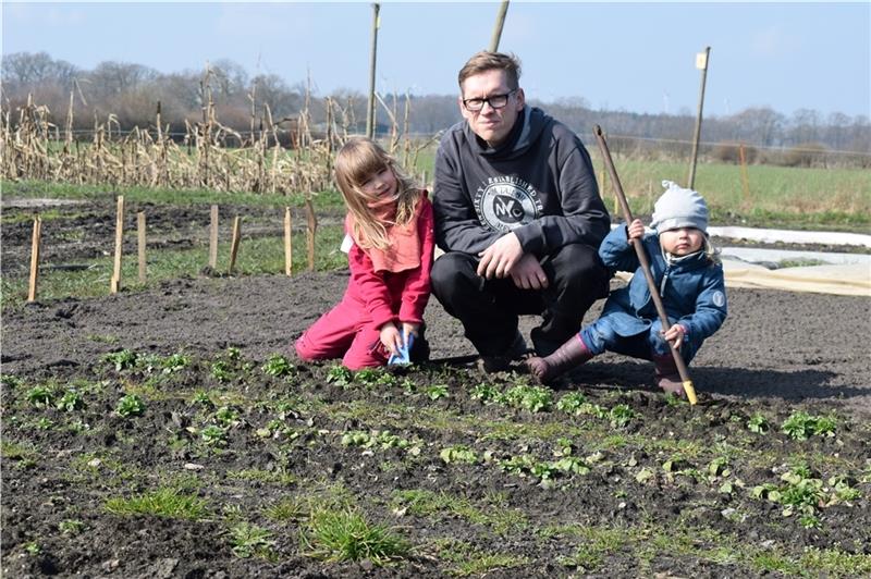 Der 2. Vorsitzende Michael Vieten-Wirtz ist mit seinen Töchtern bei der Gartenarbeit. Nebenbei schmeckt allen ein Blatt Feldsalat.