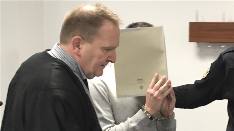 Lloyd-Attentat: So sehr belastet das Erlebte Passanten bis heute Der 21 Jahre alte Angeklagte wird in den Gerichtssaal geführt und versteckt sein Gesicht. Foto: Mündelein