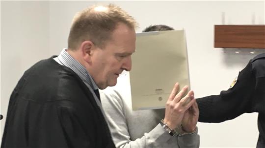 Der 21 Jahre alte Angeklagte wird in den Gerichtssaal geführt und versteckt sein Gesicht. Foto: Mündelein