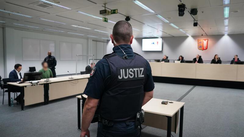 Der Angeklagte Ibrahim A. (hinten 2.v.l) sitzt im Gerichtssaal im China Logistic Center.