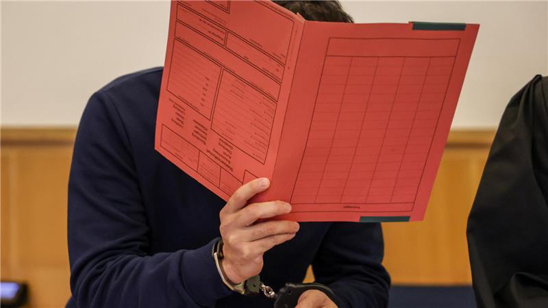 Überraschung im Stader Clan-Prozess: Verteidiger plädieren auf Freispruch Der Angeklagte hält sich einen Aktenordner vor das Gesicht.
