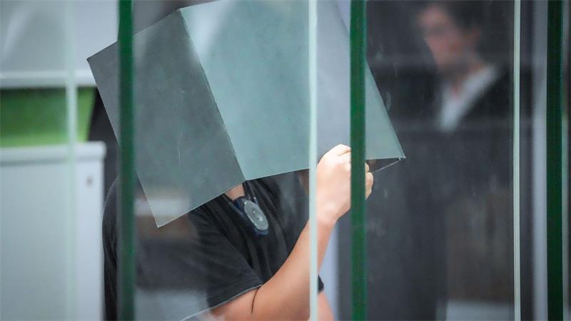 Betäubt, vergewaltigt und gefilmt - Was treibt Täter an? Der Angeklagte hält sich zum Beginn des Prozesstages im Kriminalgericht Moabit einen Aktenordner vors Gesicht. (Archivbild)