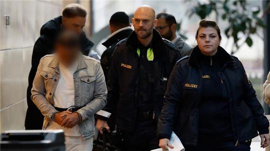 Der Angeklagte (l) wird in Handschellen zum Sitzungssaal im Landgericht Würzburg gebracht.