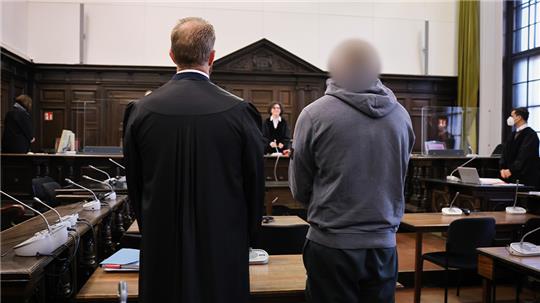 Der Angeklagte (r) und sein Anwalt stehen zu Prozessbeginn vor Ulrike Schönfelder (hinten, M), Vorsitzende Richterin am Landgericht, im Gerichtssaal im Strafjustizgebäude.  Foto: Christian Charisius/dpa