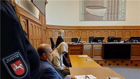 Der Angeklagte sitzt im Gerichtssaal in Stade und hat sich die Kapuze weit ins Gesicht gezogen.