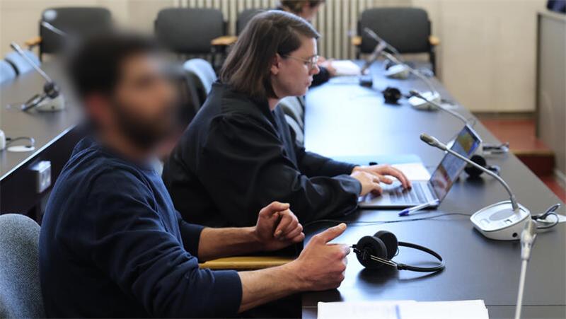 Der Angeklagte und seine Rechtsanwältin sitzen in einem Gerichtssaal.