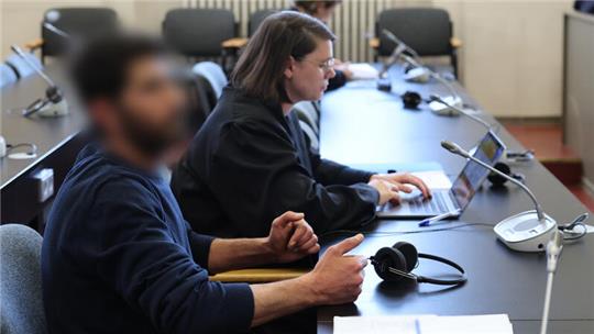 Der Angeklagte und seine Rechtsanwältin sitzen in einem Gerichtssaal.