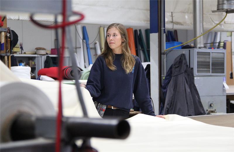 Der Arbeitstisch der Segelmacherin Meike Rinck ist so groß, dass eine Lkw-Plane drauf passt. Im Hintergrund lehnen die verschiedenfarbigen PVC-Rollen an der Wand. Foto: Meybohm