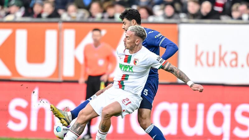 Bayern vorerst Tabellenführer - BVB verliert erneut Der Augsburger Phillip Tietz (l) im Zweikampf mit Hoffenheims Ozan Kabak.