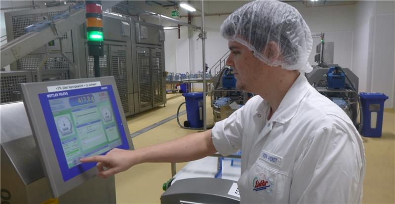 Der Auszubildende Robin Ahrendt kontrolliert eine Produktionsanlage.