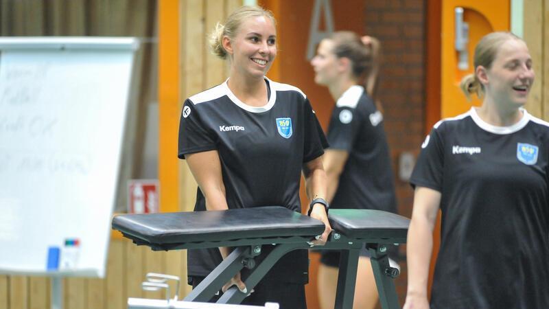 Oliwia Kamisnka grinst und schleppt eine Hantelbank durch die Halle Nord.