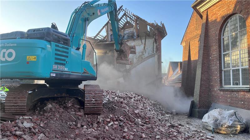 Der Bagger arbeitet sich mit dem Greifer durch den Frisörsalon am Vordamm in Horneburg.